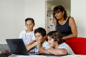 four people in front of computer