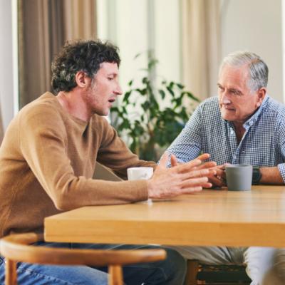 Two men sitting at a table talking