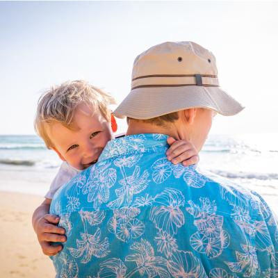 Man carrying young child at the beach