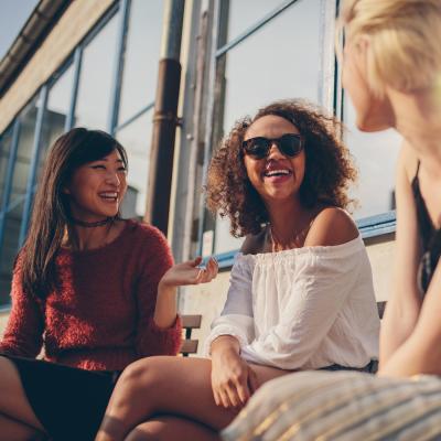 Three women sitting and talking and laughing