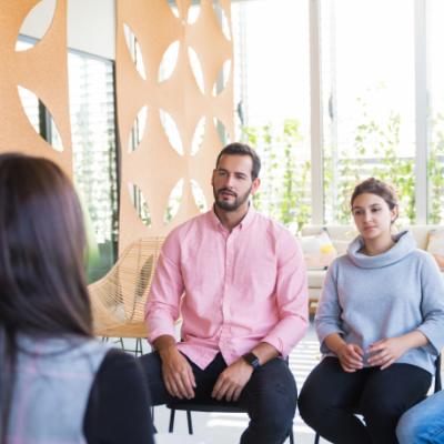 Man and woman sitting and listening to a person speaking