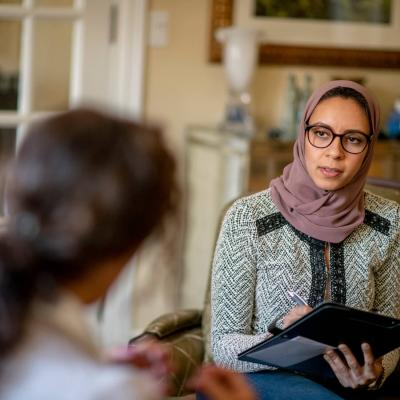 a person in a headscarf holding a clipboard and pen