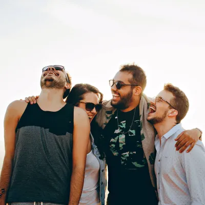 a group of people standing together and hugging and laughing